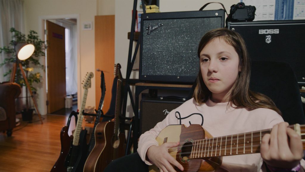 Harsh LED lighting on girl playing a guitar